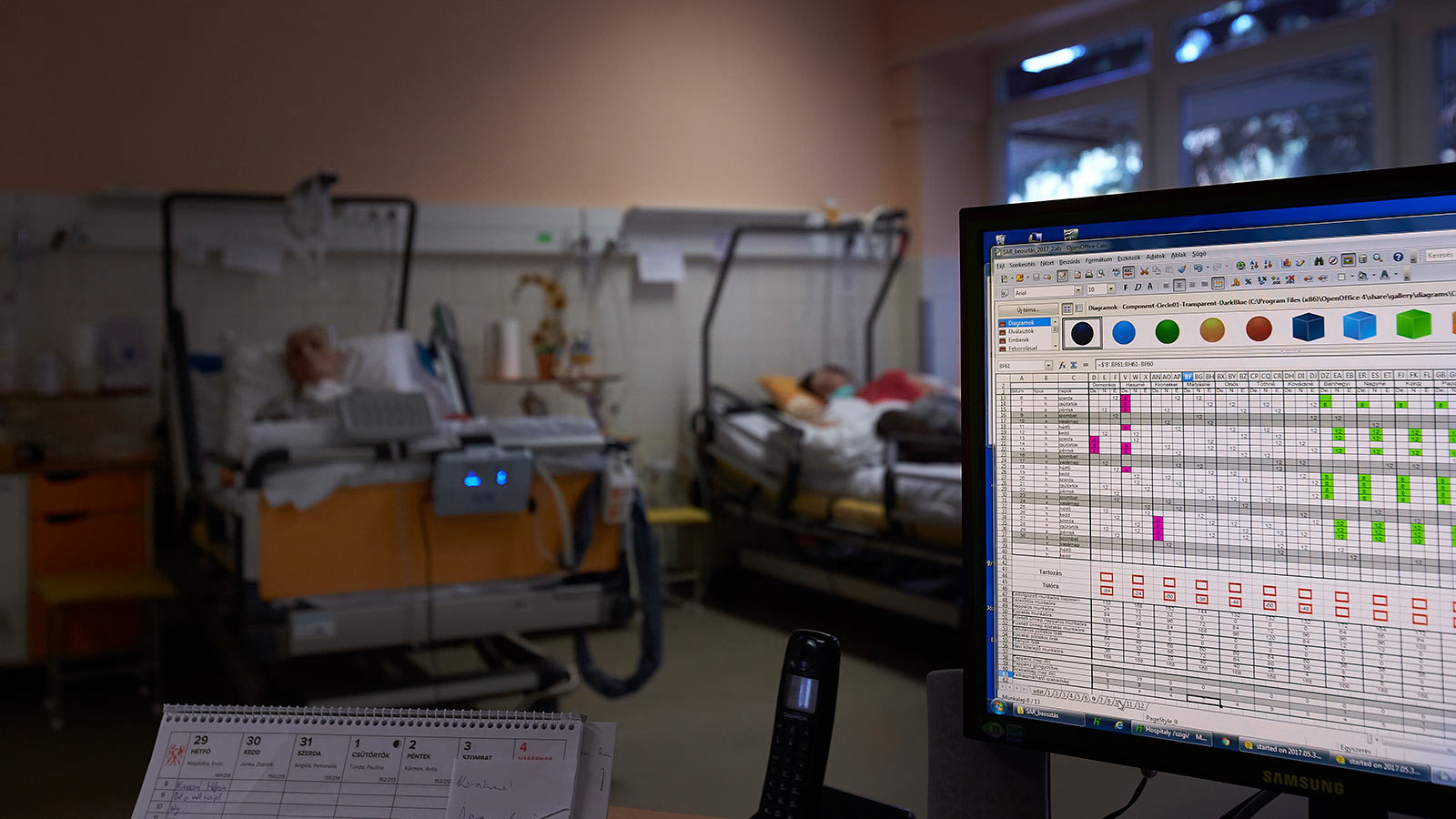 Betegmegfigyelő monitor, a háttérben betegágyak